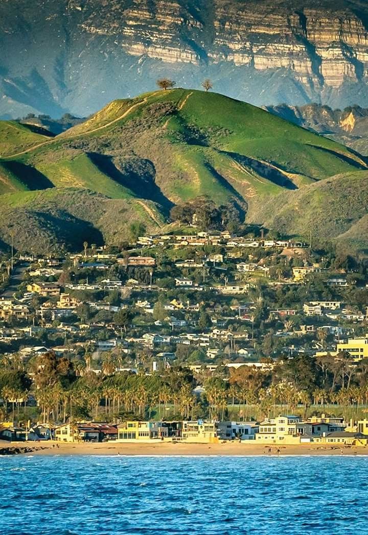 a city on the side of a mountain next to water