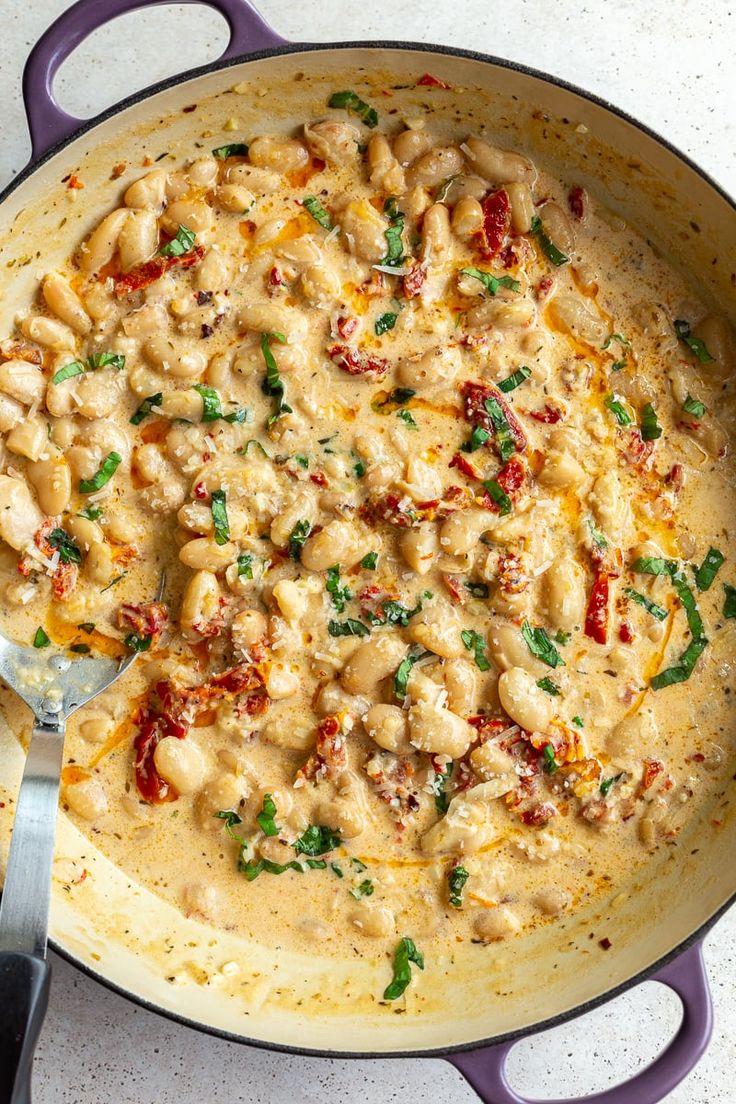 a skillet filled with pasta and sauce on top of a table