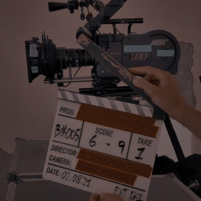 a person holding a movie clapper in front of a camera