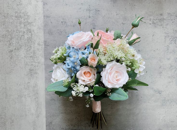 a bouquet of flowers sitting on top of a cement wall next to a planter