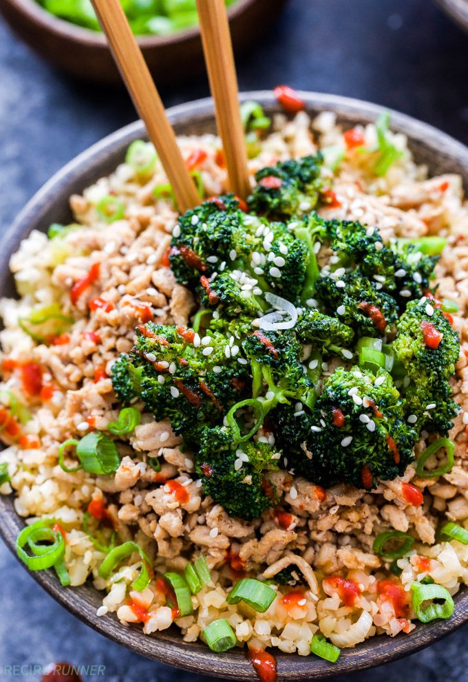 a bowl filled with rice, broccoli and chopsticks