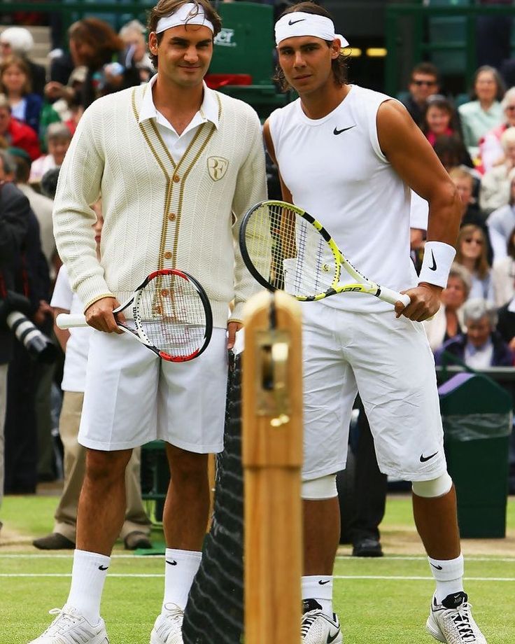 two tennis players standing next to each other holding racquets on a court