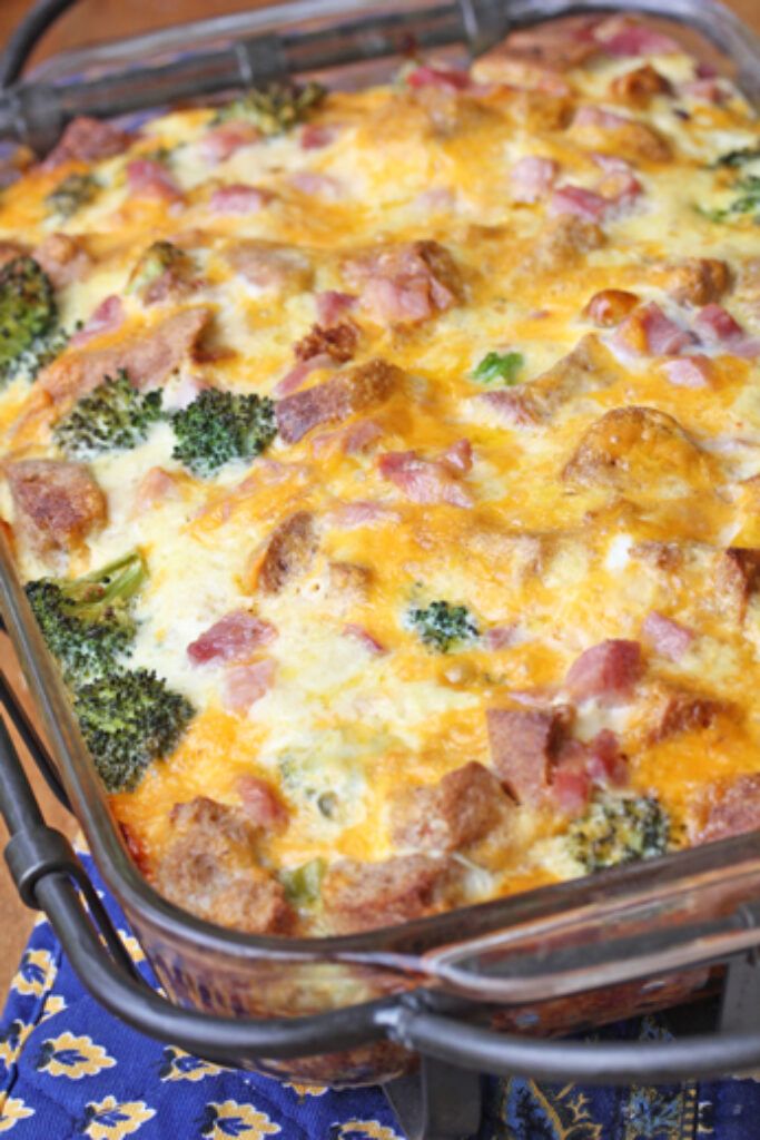 a casserole dish with ham and broccoli in it on a table