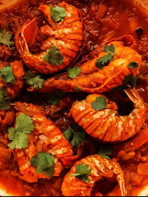 a bowl filled with cooked shrimp and garnished with cilantro