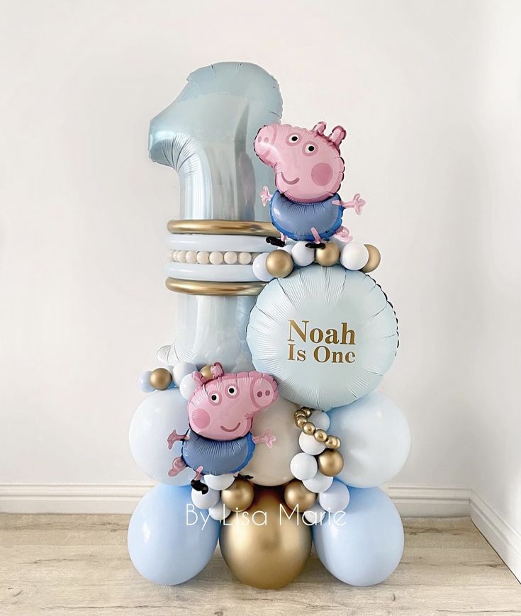 a number one balloon with pep the pig on top and balloons around it that say noah is one