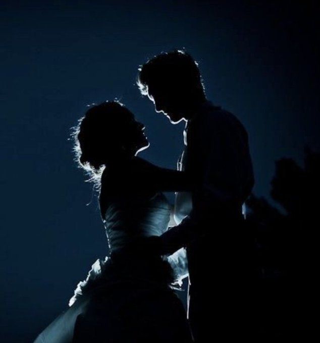 a man and woman dancing in the dark