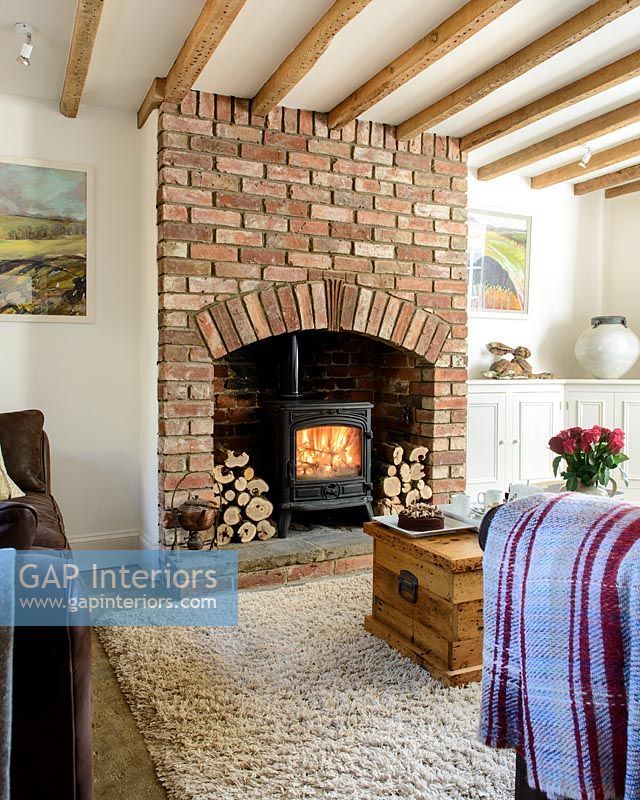 a living room with a fire place in the fireplace and rugs on the floor