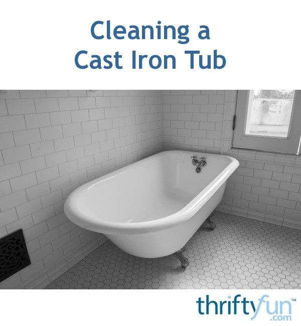 a white bath tub sitting in a bathroom next to a window with the words cleaning a cast iron tub