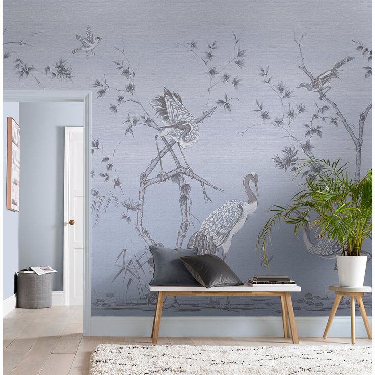 a living room wall with birds and flowers painted on the wall next to a coffee table