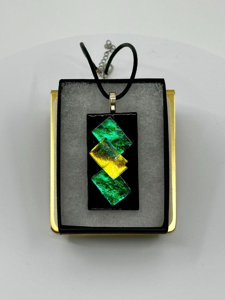 This stunning dichroic glass necklace is handmade by yours truly here in Eau Claire, Wisconsin. This beautiful one-of-a-kind piece measures 2" in height, and 1" in width. Each piece is topped with a sterling silver plated bail and comes with a 20" black leather cord upon purchase. Soldered Czech Glass Jewelry Gift, Unique Iridescent Glass Necklaces, Nickel-free Murano Glass Jewelry For Gifts, Nickel-free Murano Glass Jewelry Gift, Iridescent Glass Necklaces As Gifts, Multicolor Recycled Glass Jewelry As A Gift, Multicolor Recycled Glass Jewelry For Gifts, Artistic Green Glass Jewelry, Necklace With Large Glass Pendant As Gift