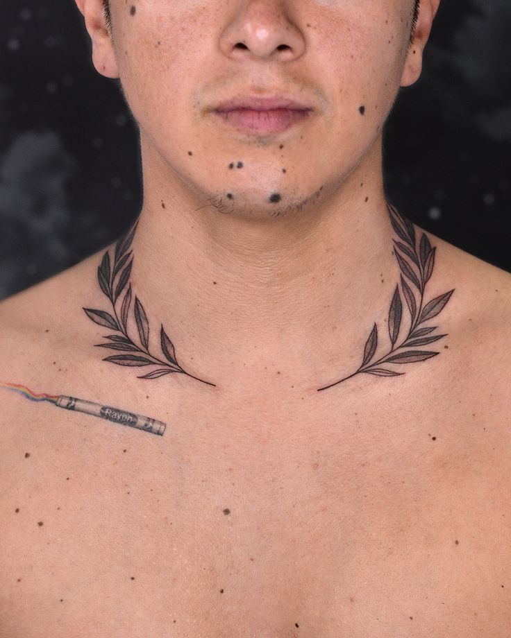 a man with tattoos on his chest is looking at the camera and has an arrow tattoo on his chest