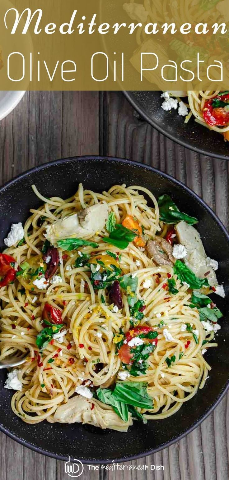 two black plates with pasta and vegetables on them, one has fettuccine