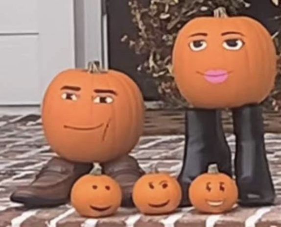 three pumpkins with faces on them sitting in front of a door and two people standing next to each other