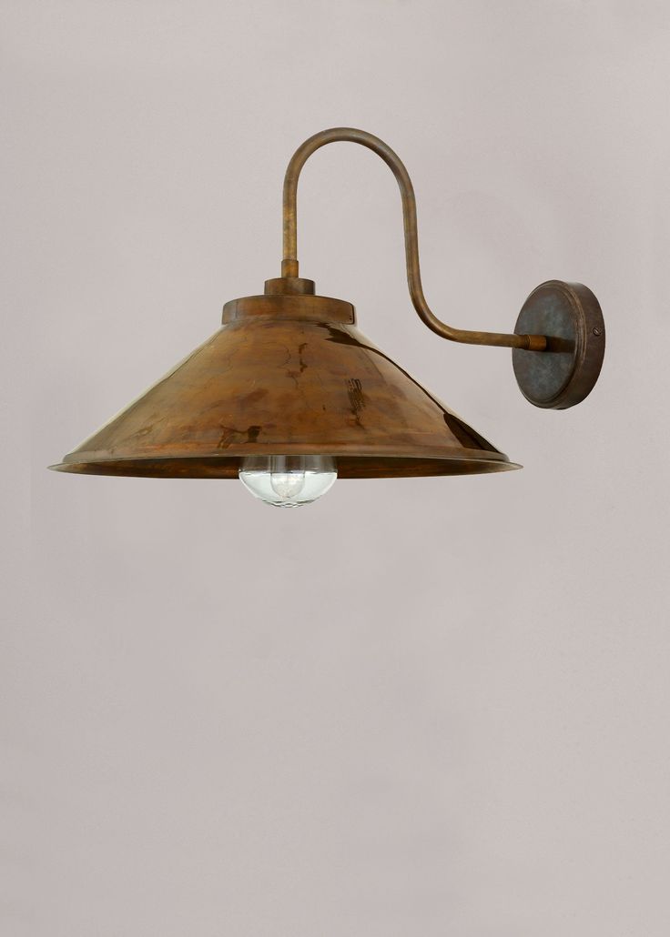 an old fashioned wall light with a glass bulb on the side and a metal arm