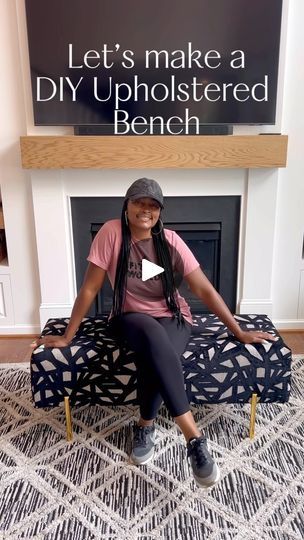 a woman sitting on top of a bench in front of a fireplace with the words let's make a diy upholsted bench