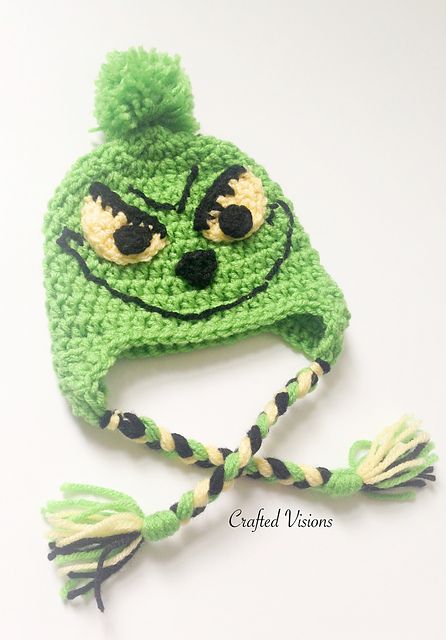 a crocheted green hat with black eyes