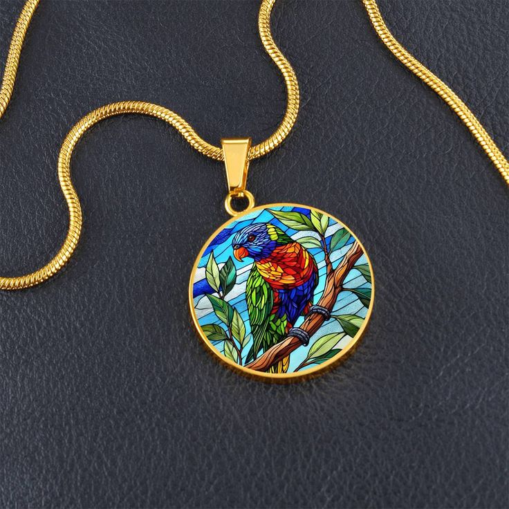 Capture the vibrant beauty of the Rainbow Lorikeet with this stunning pendant necklace. The intricate design showcases the bird's multicolored plumage in rich hues of blue, green, yellow, and red. Perfect for nature lovers and bird enthusiasts, this piece adds a splash of color and a touch of the wild to any outfit. Forged from premium surgical steel and available with a lavish 18k gold finish, this innovative jewelry boasts our exclusive design, handcrafted with care right here in the U.S.A by Round Pendant Necklace With Bird Design For Gift, Bird Design Necklace Gift, Necklace With Round Pendant And Bird Design For Gifts, Round Necklace With Bird Design For Gift, Bird Design Round Pendant Jewelry For Gifts, Bird Design Round Pendant Jewelry As Gift, Bird Design Round Pendant Jewelry Gift, Gift Jewelry With Bird Design Round Pendant, Round Pendant Jewelry With Bird Design For Gift