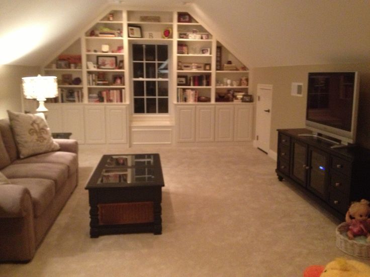 a living room with a couch, television and entertainment center in the middle of it