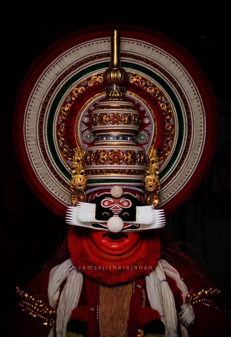 an elaborately decorated mask on display in a dark room