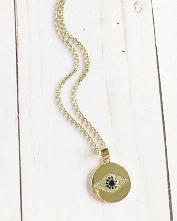 This necklace is a real blessing. Take it everywhere with you to protect you from evil spirits.Features a bright sapphire CZ diamond in the center of a round pendant with a carved evil eye on a delicate, adjustable chain. Gold plated.Length: 17.5 in Chain extender: 2 in Gold Medallion Necklace With Evil Eye, Gold Necklaces With Diamond Eyes In Round Pendant, Gold Round Pendant Necklace With Diamond Eyes, Symbolic Necklace With Adjustable Chain And Round Pendant, Gold Plated Evil Eye Round Pendant Jewelry, Symbolic Charm Necklaces With Adjustable Chain, Gold Round Evil Eye Jewelry, Gold Evil Eye Round Jewelry, Round Amulet Medallion Necklace With Adjustable Chain