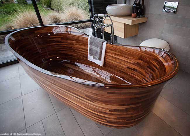 a large wooden bathtub sitting on top of a tiled floor