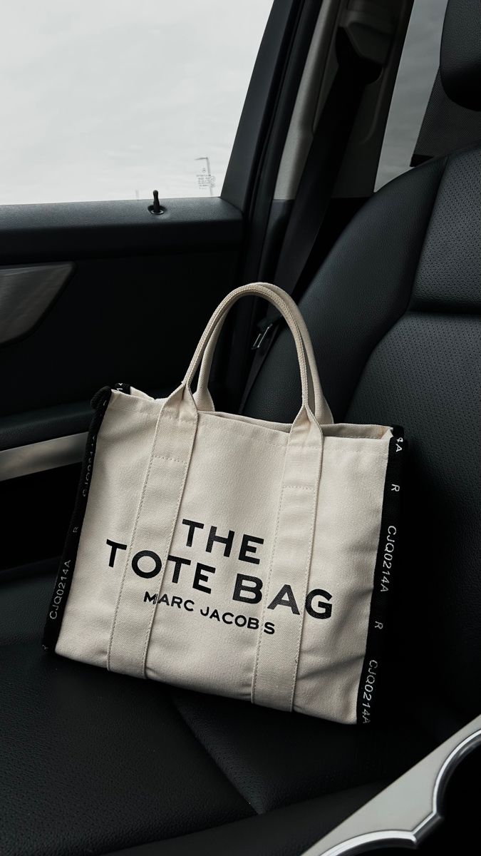 designer tote bag in passenger seat Marc Jacobs The Tote Bag, Marc Jacobs Tote Bag, Expensive Bag, Marc Jacobs Tote, Tote Bag Black, Luxury Purses, Bags Aesthetic, The Tote Bag, Cute Purses