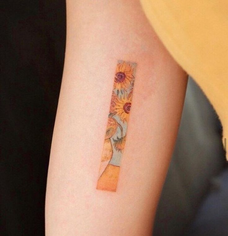 a woman's arm with a sunflower tattoo on the left side of her arm