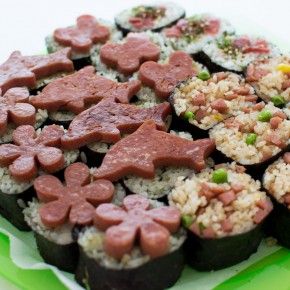 an assortment of sushi on a plate with chopsticks in the shape of dogs