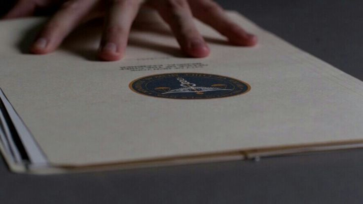 two hands on top of a book with the seal of approval written in blue and white