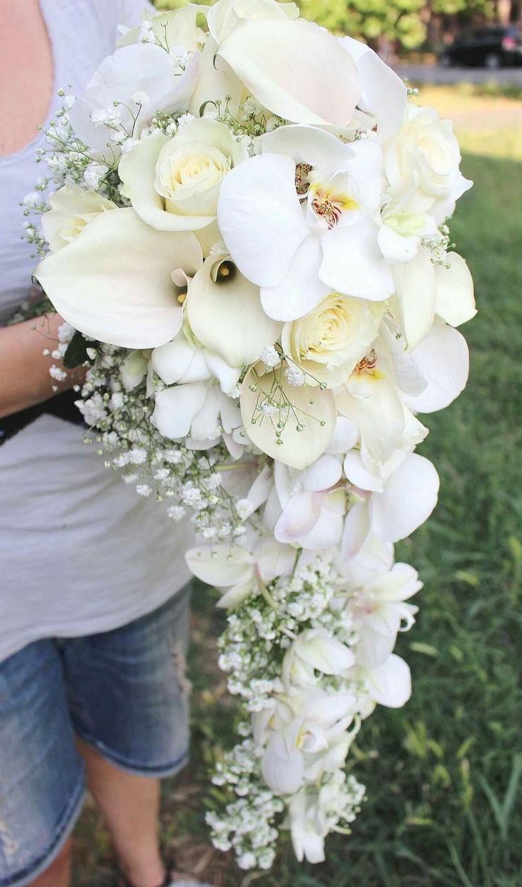 a woman holding a bouquet of white flowers