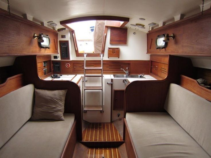 the inside of a sailboat with two couches and a sink in the center