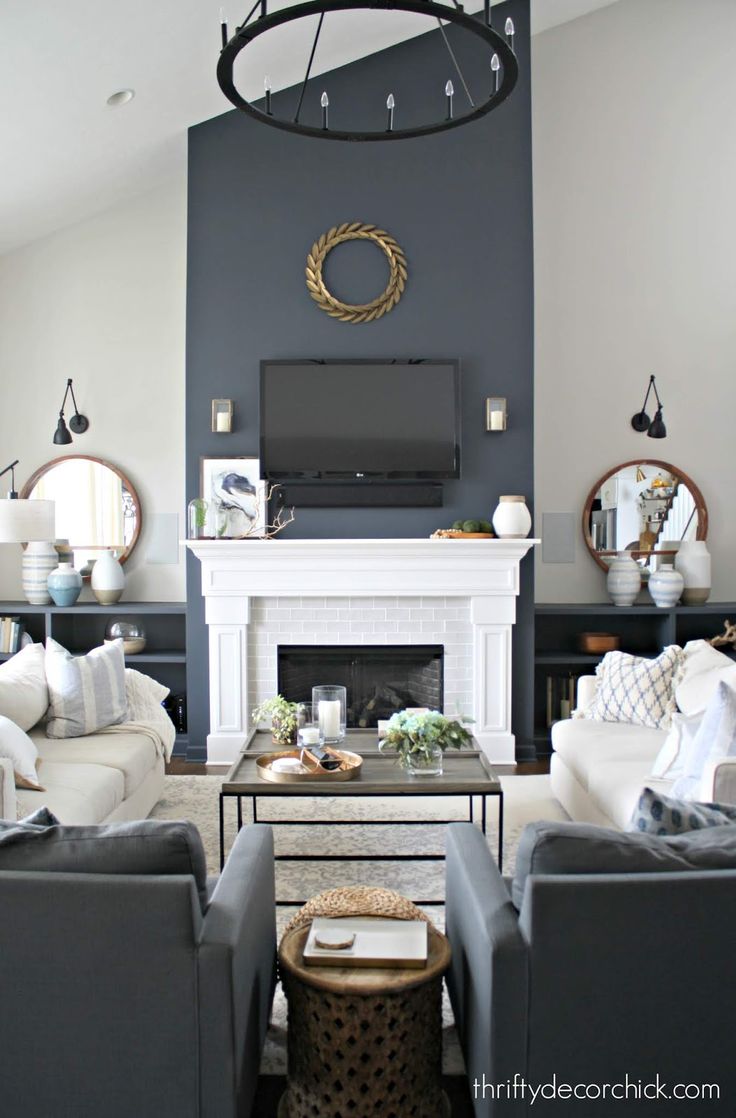 a living room filled with furniture and a flat screen tv mounted on the wall above a fireplace