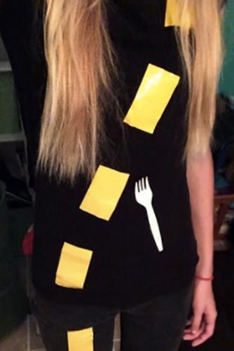 a woman with long blonde hair wearing a black shirt and yellow tape around her neck