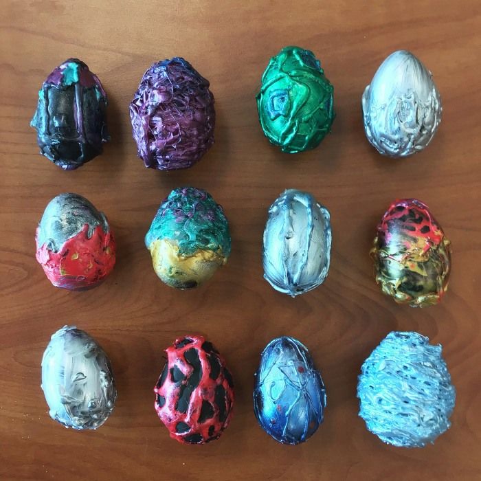 six different colored eggs sitting on top of a wooden table