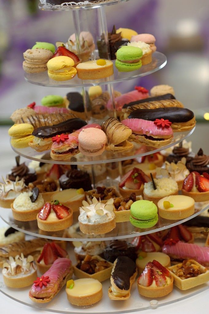 a three tiered tray filled with different types of pastries and desserts on top of each other