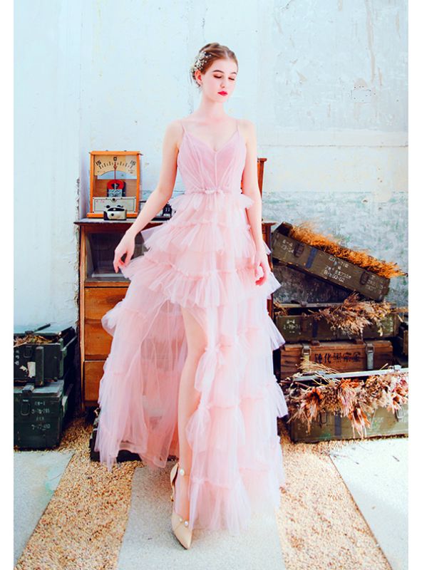 a woman in a pink dress standing next to a dresser