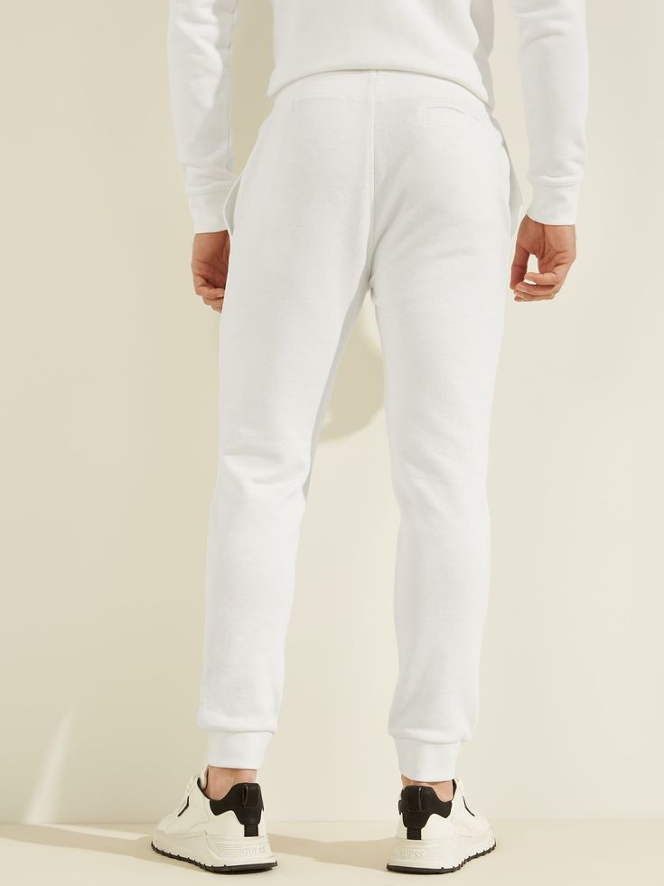 This pair of pants features a drawstring waistband, a back welt and side-seam pockets, a monochromatic logo and ribbed trim. Contains recycled and organic cotton fibers. Relaxed Fit Cotton Bottoms With Logo Waistband, Cotton Bottoms With Logo Waistband And Relaxed Fit, Cotton Jogging Pants With Logo Detail, Cotton Athleisure Sweatpants With Logo Waistband, Casual Cotton Joggers With Logo Waistband, Casual Cotton Pants With Logo Waistband, Cotton Bottoms With Logo Waistband For Spring, Cotton Bottoms With Logo Waistband For Loungewear, Cotton Joggers With Logo Waistband For Jogging