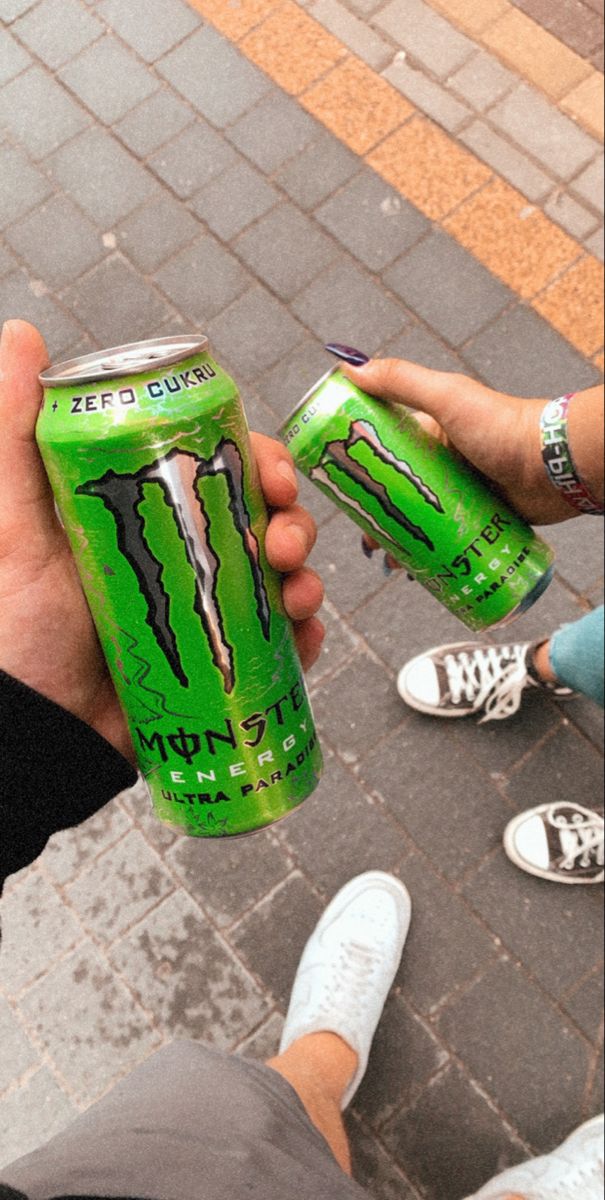 a person holding a can of monster energy drink