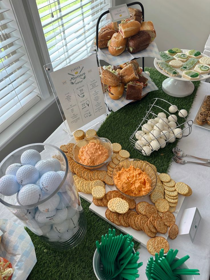 a table filled with snacks and desserts on top of green carpeted flooring