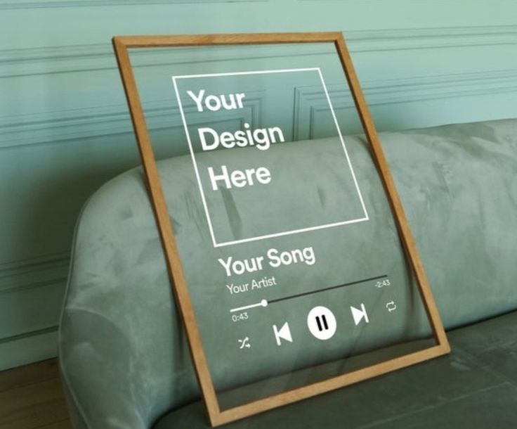 a wooden sign sitting on top of a couch next to a gray sofa with an mp3 player