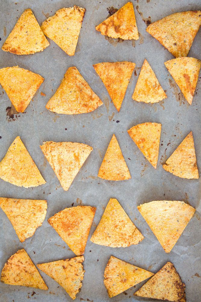 some tortilla chips are on a baking sheet and ready to be baked in the oven