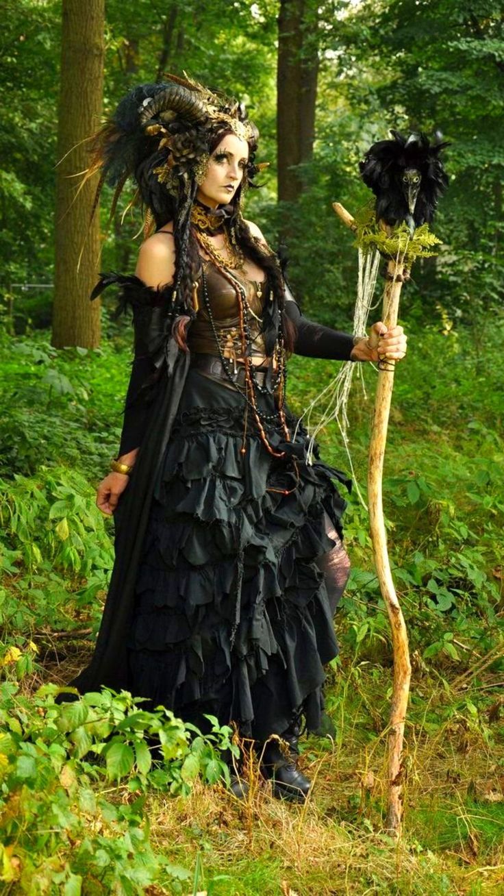 a woman dressed in black holding a stick