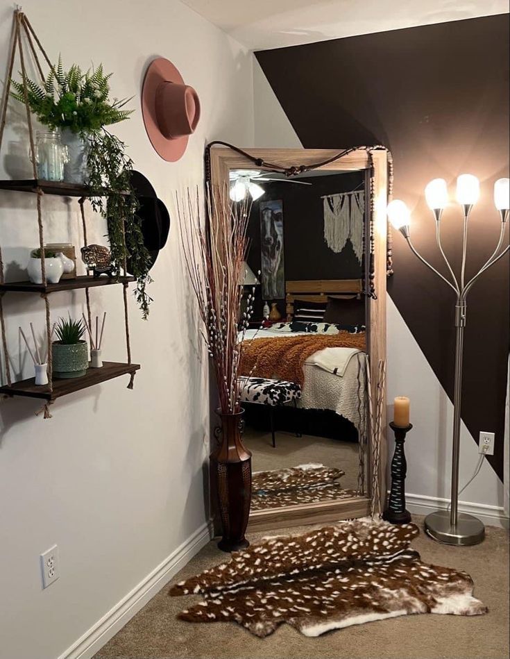 a mirror sitting on top of a floor next to a shelf filled with potted plants