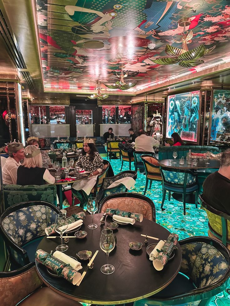 people sitting at tables in a restaurant with colorful ceiling tiles on the walls and floor