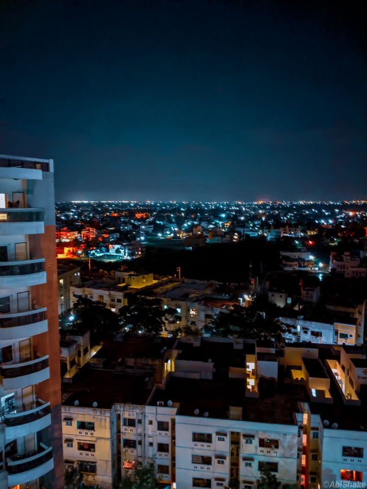 the city is lit up at night with bright lights in the sky and buildings on both sides