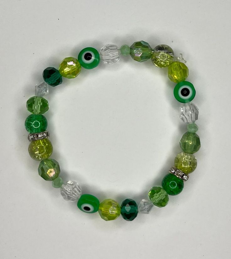 A green evil eye bracelet I made. Green Evil Eye Bracelet, Green Spiritual Stretch Bangle Bracelet, Spiritual Green Bangle Bracelet, Green Evil Eye Round Bead Jewelry, Green Evil Eye Round Beads Jewelry, Green Evil Eye Bead Jewelry, Green Evil Eye Jewelry With Round Beads, Green Spiritual Evil Eye Bracelet As Gift, Green Spiritual Jewelry With Evil Eye