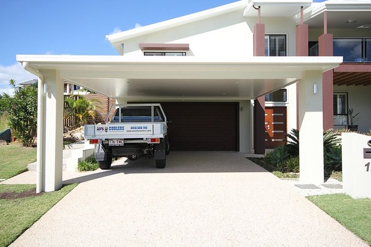 a truck is parked in front of a house with a carport attached to it