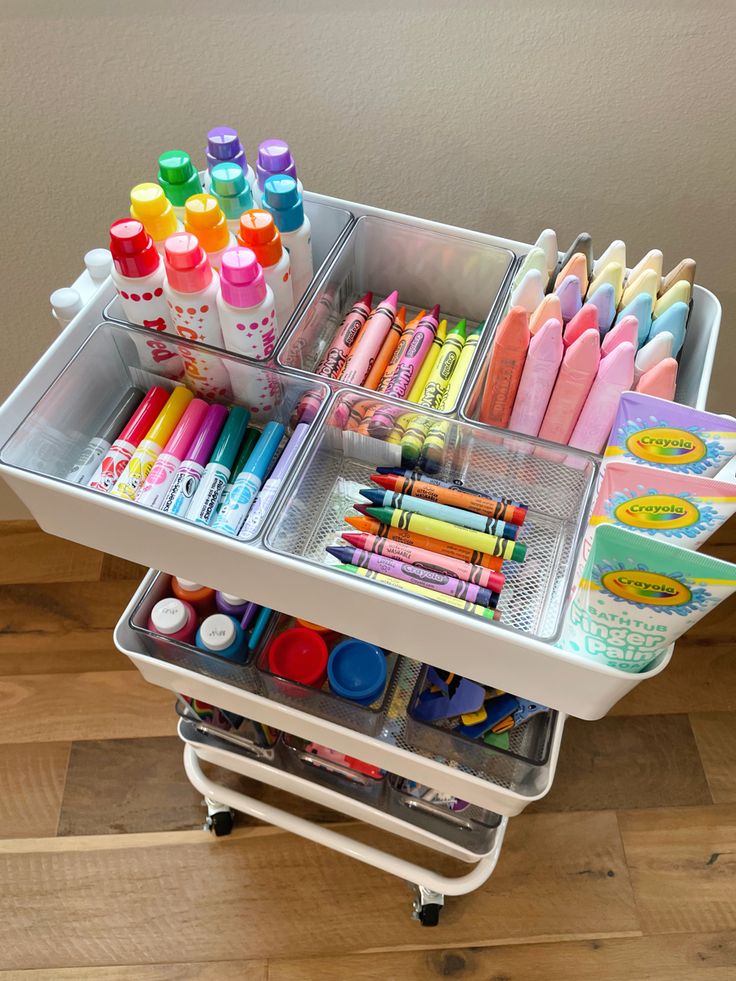 the cart is full of markers, crayons, and other crafting supplies