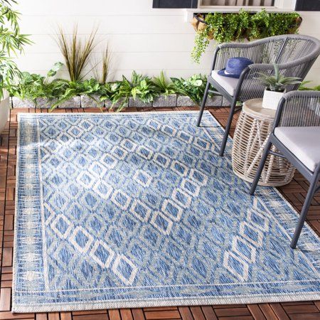 an outdoor area rug with chairs and potted plants