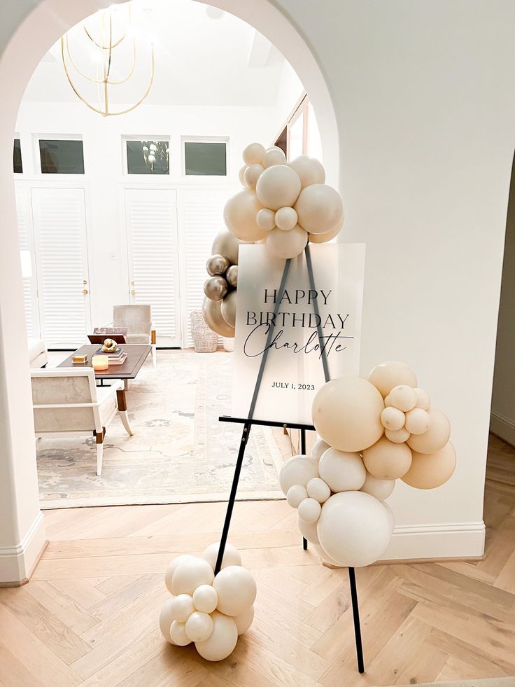 balloons are arranged in the shape of an arch for a happy birthday party at home